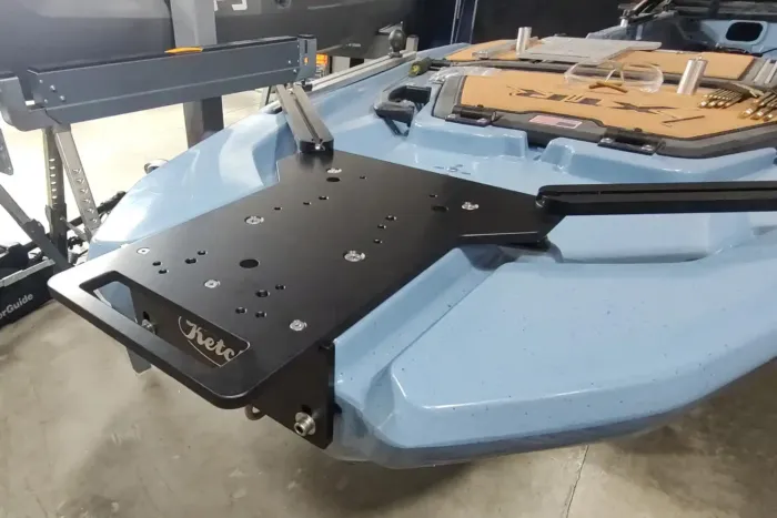 Angled front-side view of the Ketch XTR Bow Motor Mount installed on the Bonafide XTR130 kayak. The black anodized aluminum plate with Ketch logo and support rails is securely attached to the blue kayak’s bow, ready for trolling motor setup.