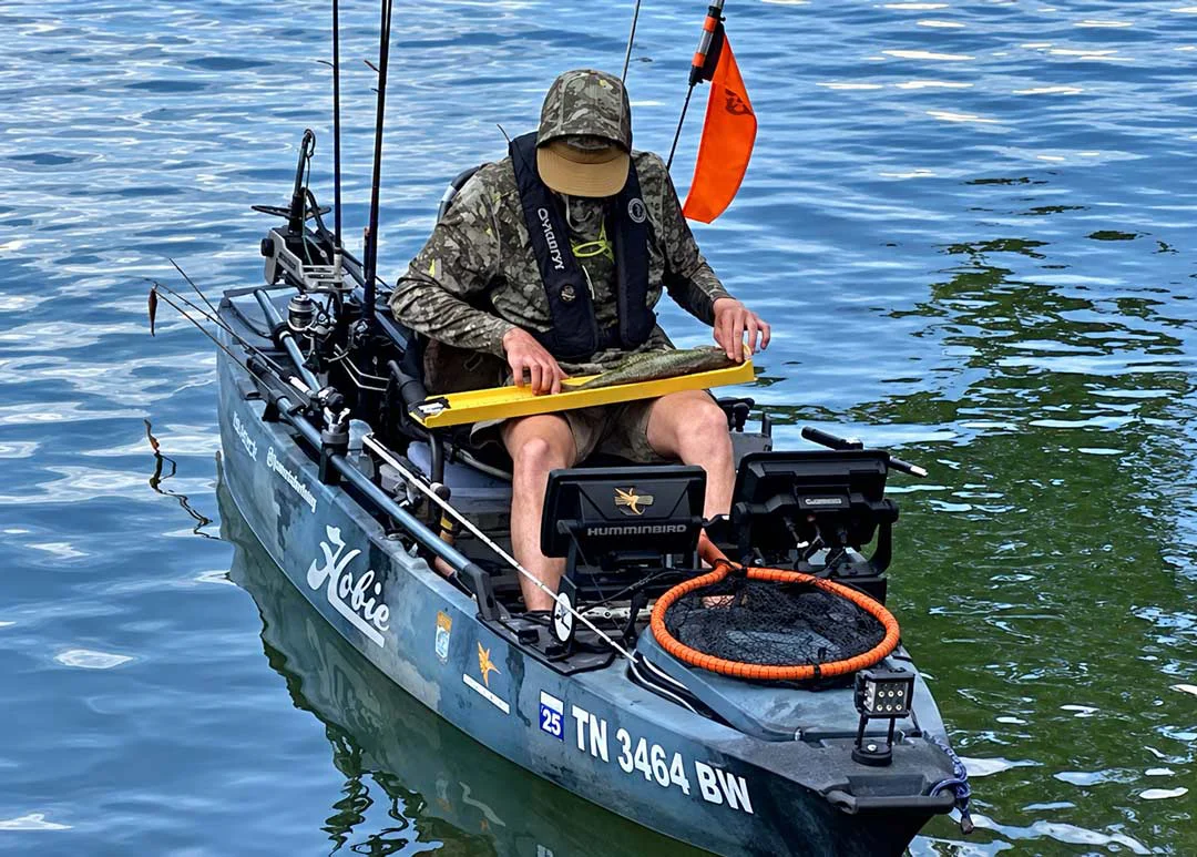 Carlton H. measures a fish on a Ketch Karbonate measuring board.