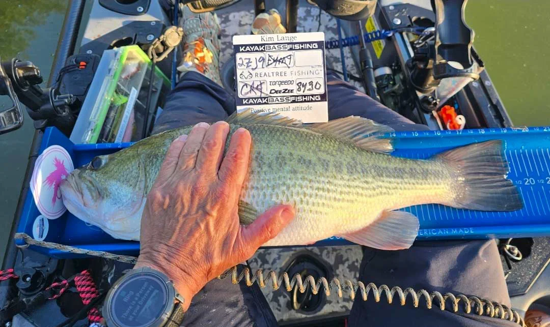 Kim L. Measures a bass on a blue Ketch X bump board during a kayak touranment.